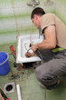 Plumber cleaning drain in bathroom with cable Plumber cleaning drain in bathroom with cable