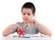 Little boy painting star fish over white.