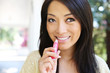 Asian Woman Putting on Lip Gloss