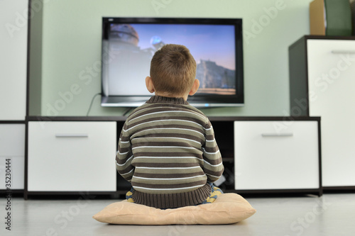 Photo : Kleinkind sitzt vor dem Fernseher und schaut einen Film Kleinkind sitzt vor dem Fernseher und schaut einen Film
