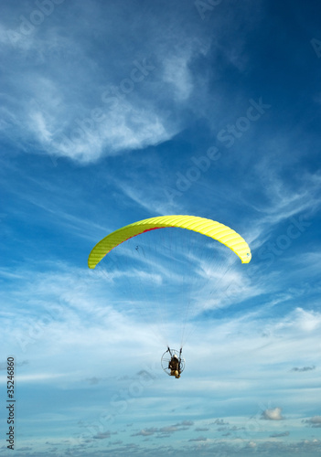 Photo: Flying paramotor in the blue sky Flying paramotor in the blue sky