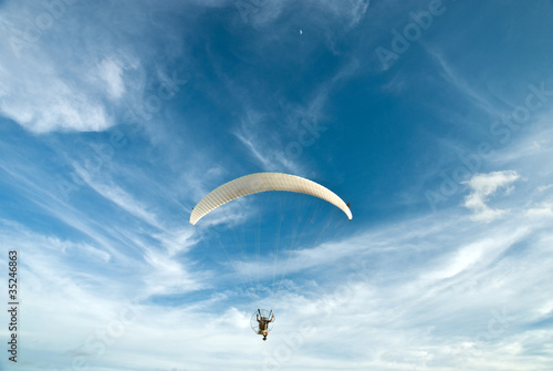 Photo: Flying paramotor in the blue sky Flying paramotor in the blue sky