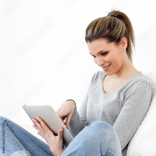 Foto: young beautiful woman on sofa with tablet young beautiful woman on sofa with tablet