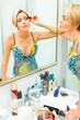 Photo: Attractive woman in bathroom applying mascara Attractive woman in bathroom applying mascara