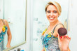 Photo: Cheerful pretty woman in bathroom extends fluffy brush in camera Cheerful pretty woman in bathroom extends fluffy brush in camera