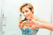 Photo: Embarrassed pretty woman in bathroom using fluffy brush Embarrassed pretty woman in bathroom using fluffy brush
