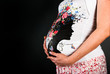 Belly pregnant woman on a black background
