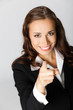 Business woman pointing finger at viewer, over grey