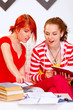 Girl helping her girlfriend studying