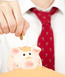 businessman putting money on a buried piggy bank businessman putting money on a buried piggy bank