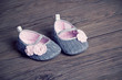 girl baby shoes placed on a wooden floor