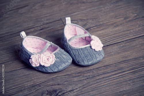 Photo: girl baby shoes placed on a wooden floor girl baby shoes placed on a wooden floor