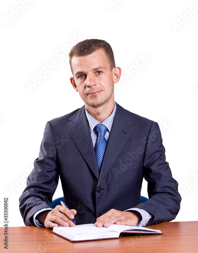 Photo: businessman sitting at his desk isolated on white businessman sitting at his desk isolated on white