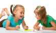Two little girls draw with markers