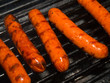 A row of five hotdogs on a bbq grill A row of five hotdogs on a bbq grill
