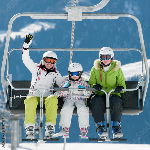 Photo: Ski lift - happy skiers on ski vacation Ski lift - happy skiers on ski vacation