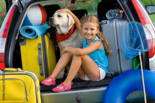Photo: Girl with dog ready for travel for summer vacation Girl with dog ready for travel for summer vacation