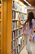 Portrait of a young woman choosing a book