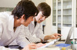 Smiling chemistry students writing a report