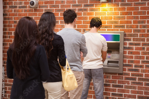 Photo: Young people queuing to withdraw cash Young people queuing to withdraw cash