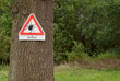 Warnschild Zecken an einem Baum am Waldrand