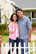 Hispanic couple outside new home
