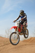 Motocross motorbike racer performs a jump