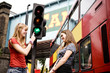 Two teenage girls taking a photograph in Camden, London