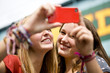 Two teenage girls taking a photograph in Camden, London
