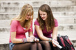 Foto: Two teenage girls sitting on steps, writing postcards Two teenage girls sitting on steps, writing postcards