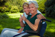 Seniorin und Pflegerin heben Daumen hoch