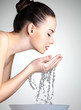 young woman washing her face with clean water