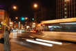 A night city street scene with a blurred bus A night city street scene with a blurred bus