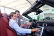Car seller showing interior details to purchaser