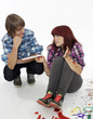 Young boy sits next to a girl covered with paints