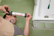 Photo: Plumber using silicone cartridge Plumber using silicone cartridge