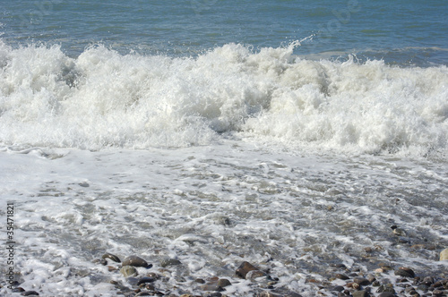 Photo: Foam of water and waves of surf on the sea coastline Foam of water and waves of surf on the sea coastline