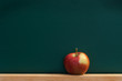 Red apple on chalkboard