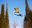 Snowboarder jumping through air with  blue sky in background