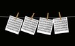 Spartiti musicali appesi su fondo nero