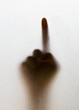 Shadow of a blurry hand behind the frosted glass