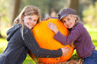 two girls proud of their big pumpkin