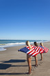 Three Young Women Wrapped in American Flags on a Beach