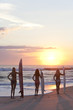 Woman Surfers In Bikinis With Surfboard At Sunset Beach