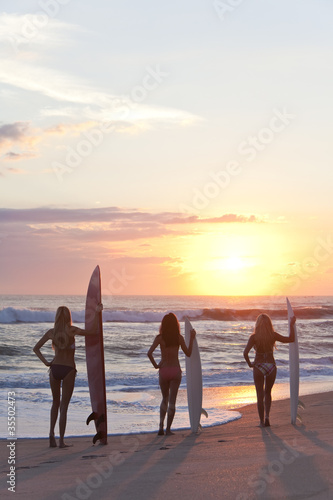 Photo: Woman Surfers In Bikinis With Surfboard At Sunset Beach Woman Surfers In Bikinis With Surfboard At Sunset Beach