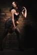 Girl with a guitar near a brick wall
