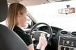 Portrait of young woman eating while driving car Portrait of young woman eating while driving car