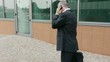 Video: Man walking near office building and talking on cell phone Man walking near office building and talking on cell phone