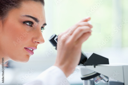 Photo: Young woman looking at a microscope slide Young woman looking at a microscope slide