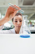 Portrait of a serious science student pouring liquid